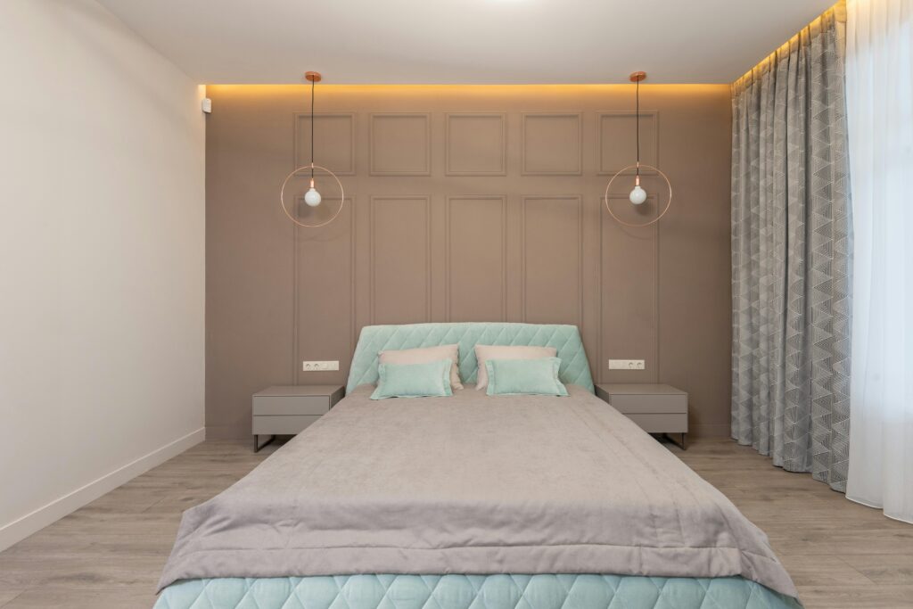pexels-photo-7533768-7533768 Comfortable bed with pillows and soft beige coverlet and bedside tables illuminated by glowing light